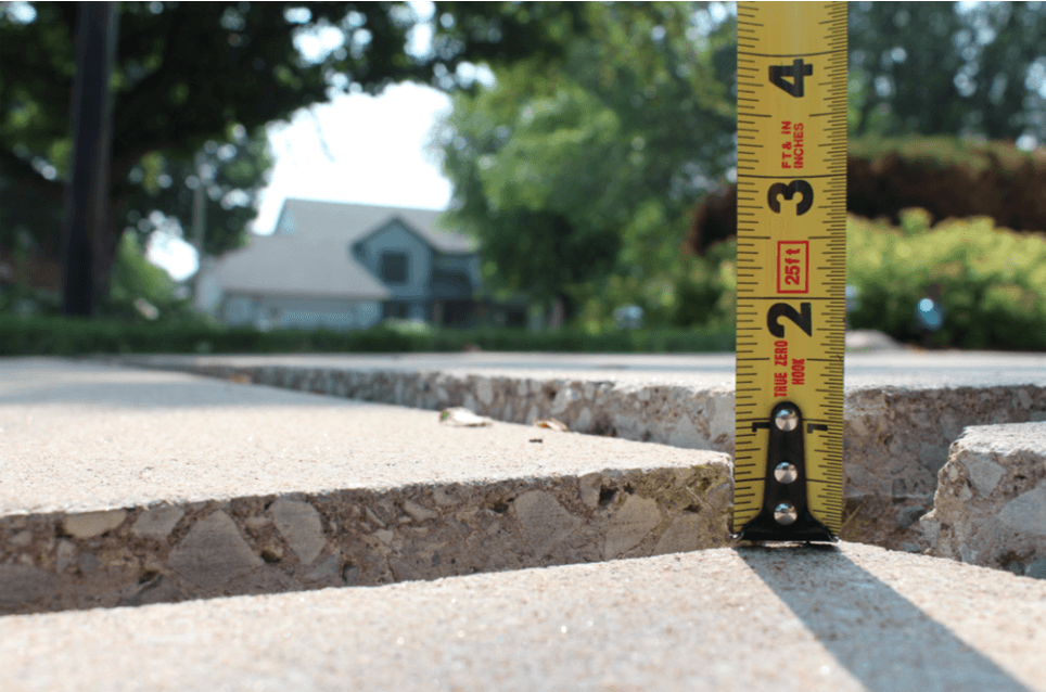 cracks in sidewalk being measured before leveling