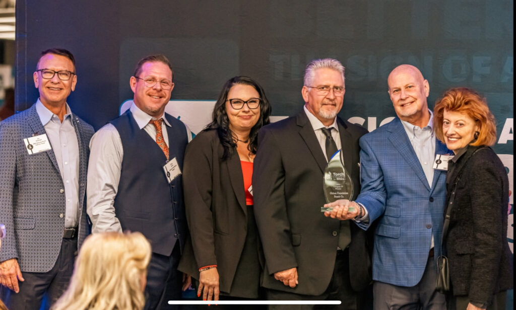 Olshan Foundation Solutions Dallas leadership team accepting the 2025 BBB Torch Award for Ethics trophy at the Better Business Bureau ceremony.