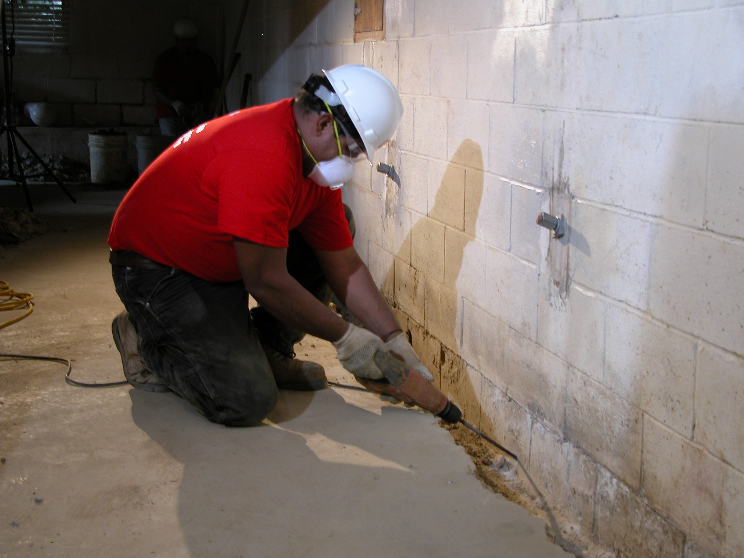 Professional installing waterproofing system in basement to ensure dry interior and safeguard home investment Professional installing waterproofing system in basement to ensure dry interior and safeguard home investment