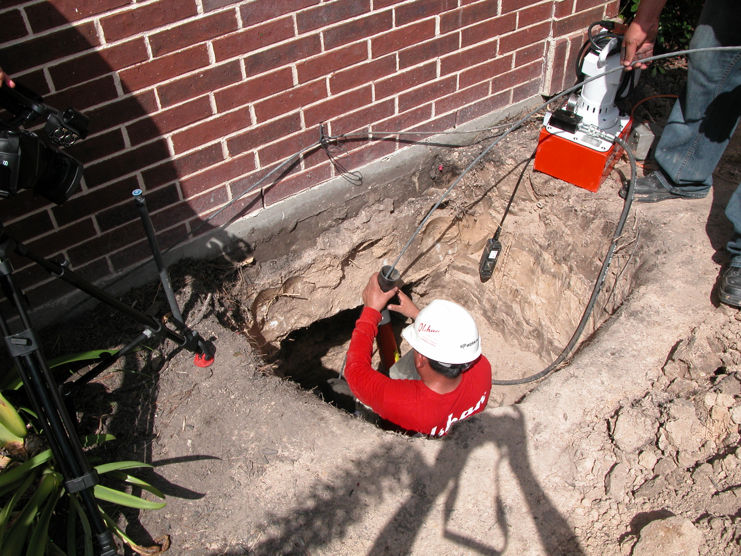 professional installing cablelock system for effective stabilization of house foundation with olshan technology A professional installing Cablelock system for effective stabilization of house foundation with Olshan technology