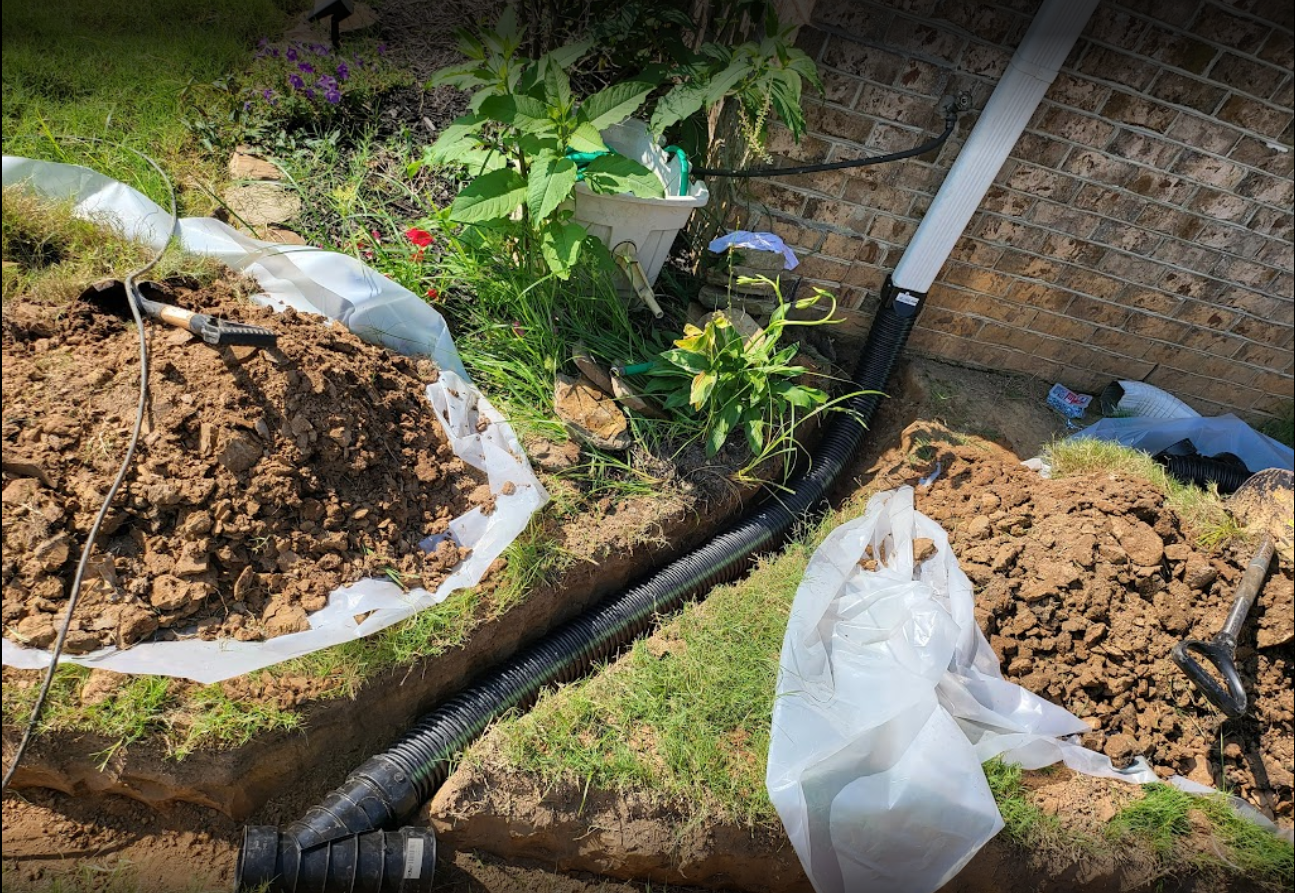 Professional French drain installation alongside a brick wall, showcasing effective landscape drainage solutions Professional French drain installation alongside a brick wall, showcasing effective landscape drainage solutions