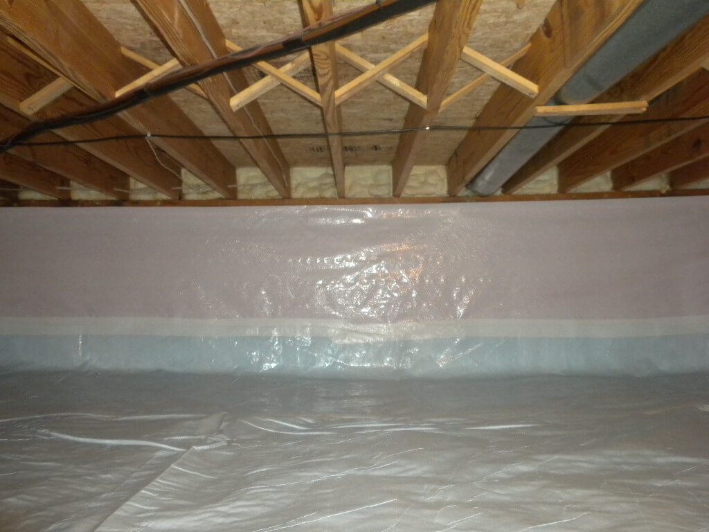 Polyethylene vapor barrier installation in progress for enhanced moisture control in basement encapsulation project